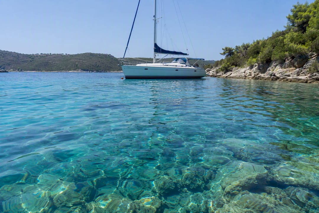 Secluded sailing boat near rocky snorkeling beach