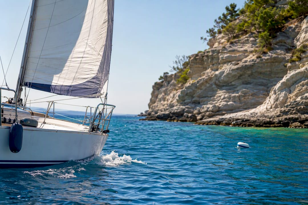 Sailing boat rounding a quiet Halkidiki bay