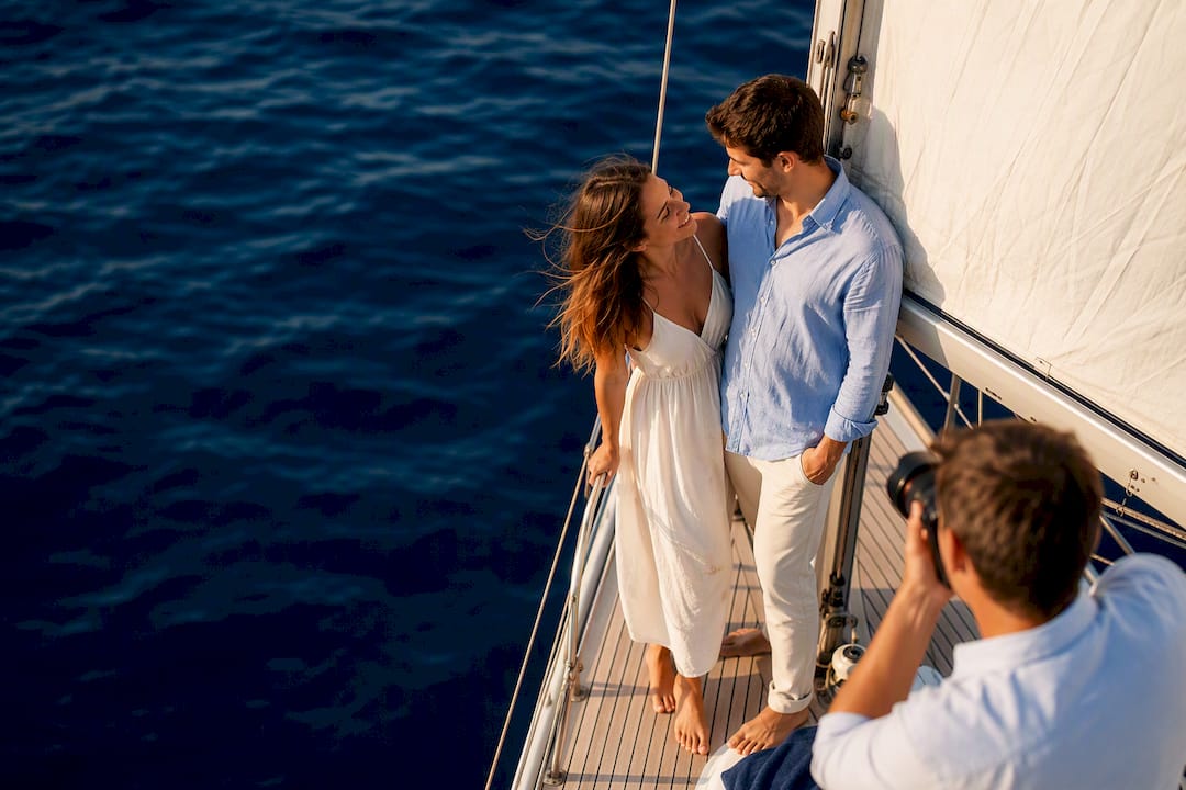 Couple posing on sailing boat at sea