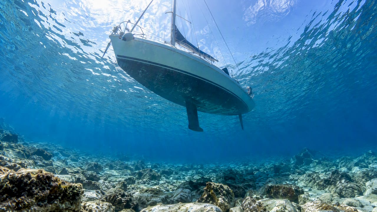 Clear Kelyfos seabed beneath sailing boat