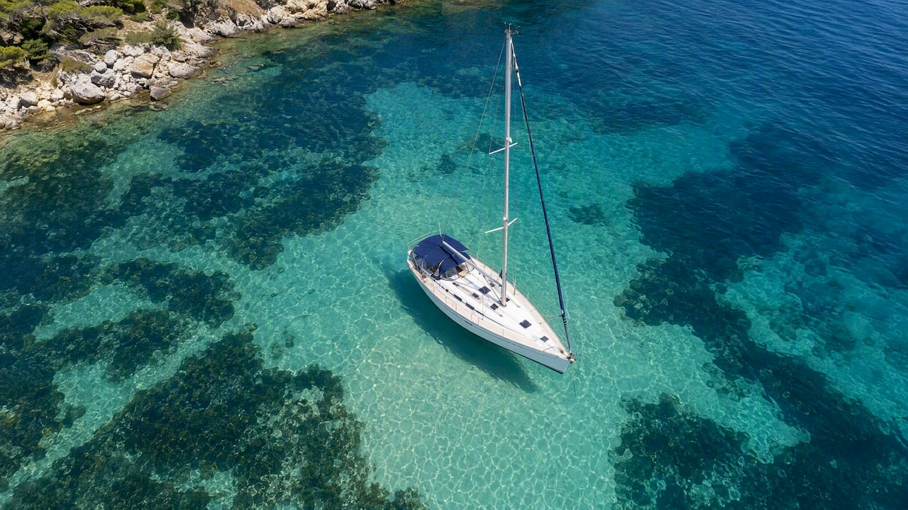 Sailing boat over sandy Halkidiki anchorage